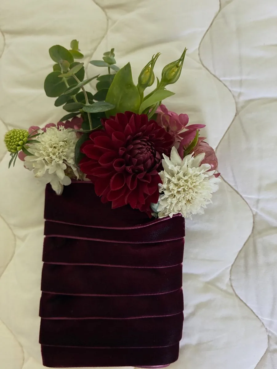 Burgundy dahlia and white flowers in a burgundy velvet wrapped wedding piece