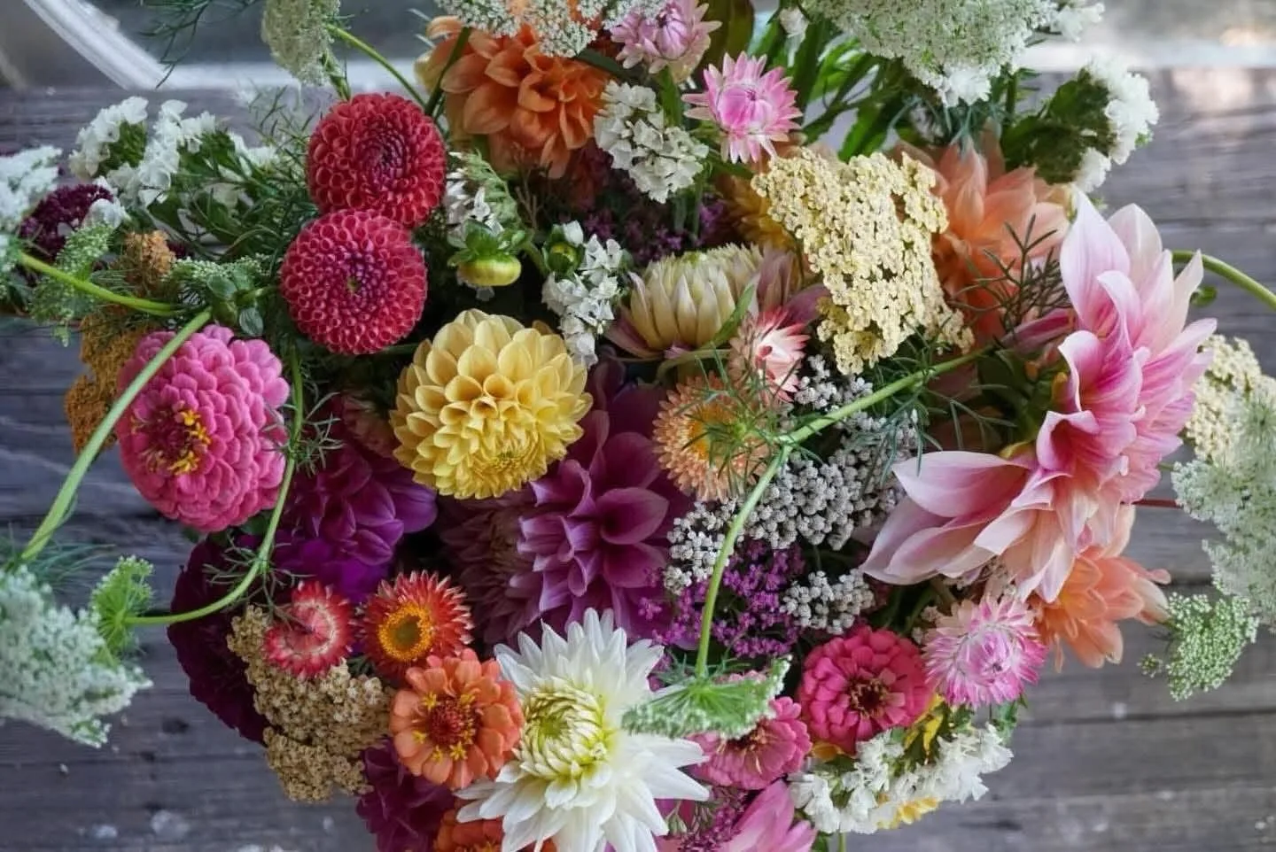 Close view of a colourful dahlia arrangement on a wooden table