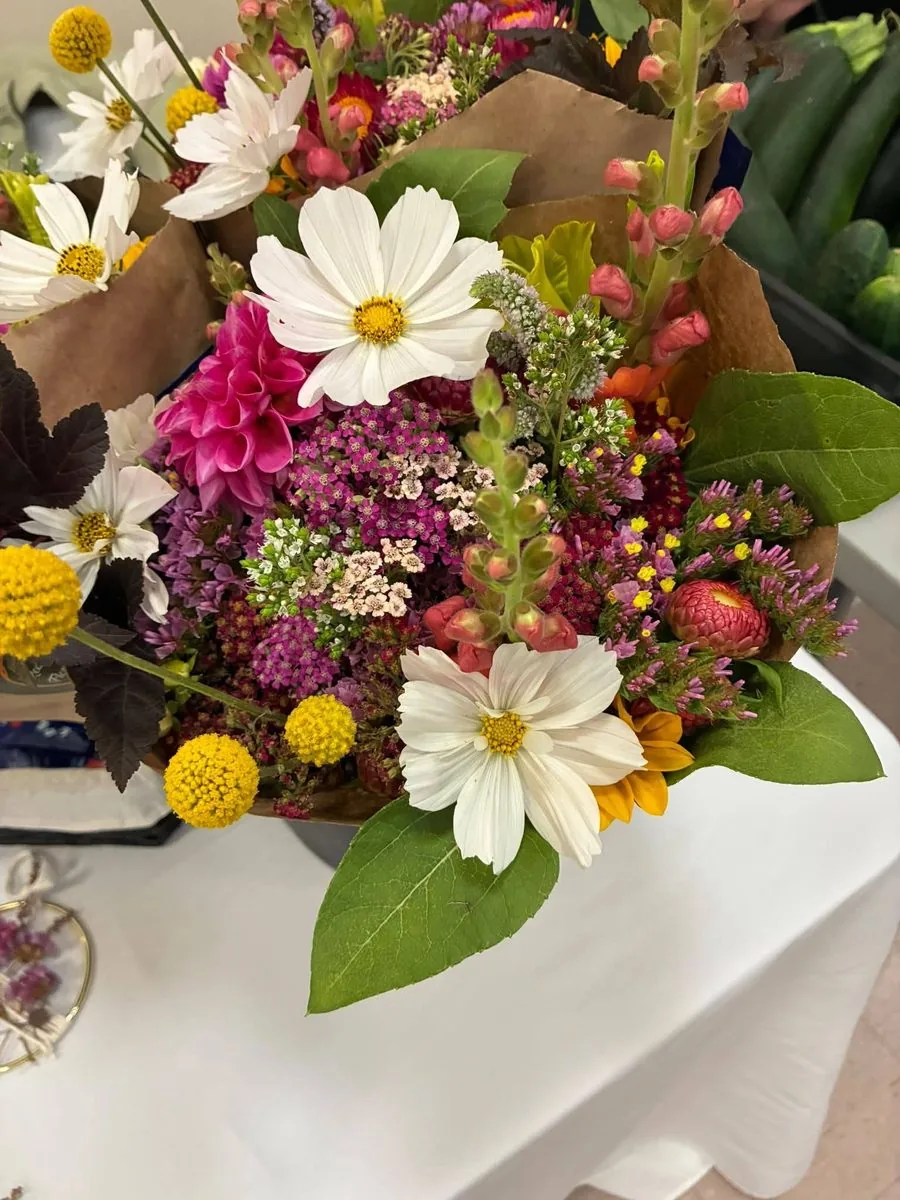 Cosmos and dahlia bouquet with yellow craspedia wrapped in kraft paper